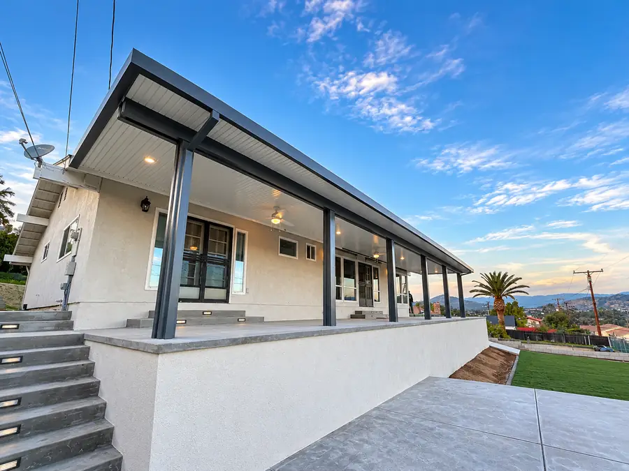 Attached solid aluminum patio covers with recessed lights and ceiling fans over a raised patio on a home in Temecula, SoCal